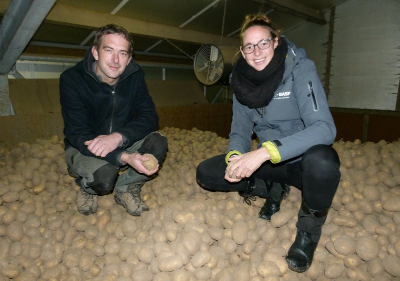 Pootgoedteler Jan-Willem van der Eijk en Agnita Wammes van BASF op aardappelbewaring met aardappels in de handen